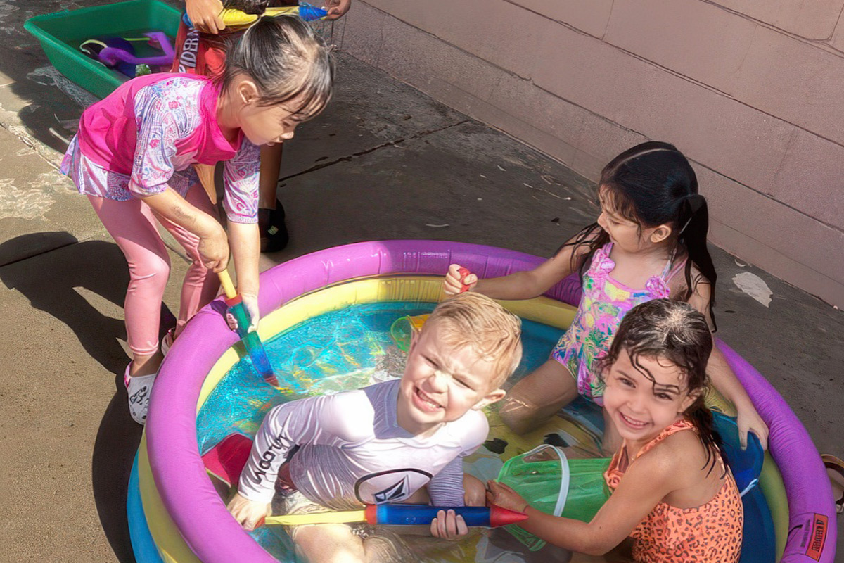Children playing in a small inflatable pool outdoors at ElevateChild preschool in Scottsdale, AZ.